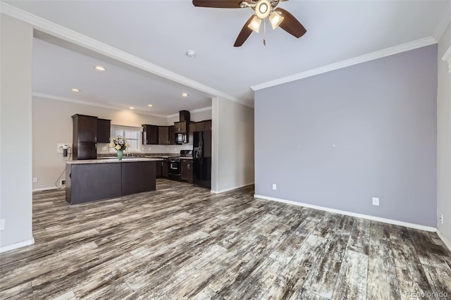 kitchen featuring a kitchen island with sink, black appliances, ornamental molding, dark brown cabinets, and dark hardwood / wood-style flooring