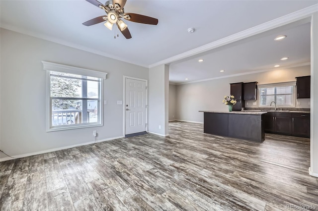 unfurnished living room featuring hardwood / wood-style flooring, ceiling fan, and ornamental molding