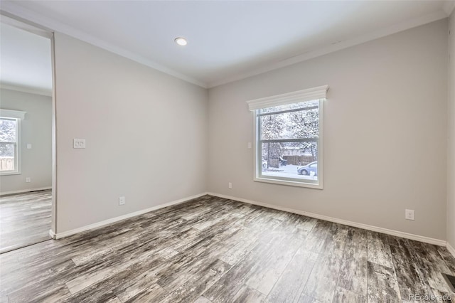 empty room with ornamental molding and hardwood / wood-style flooring