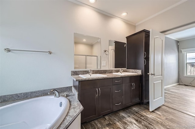 bathroom featuring hardwood / wood-style flooring, vanity, separate shower and tub, and ornamental molding