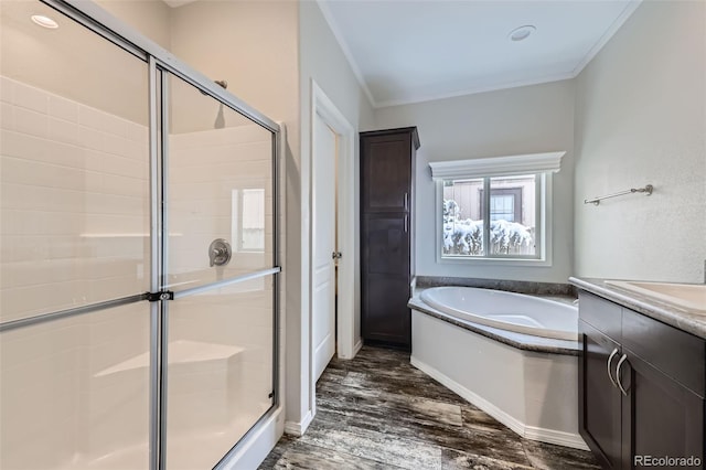 bathroom with ornamental molding, vanity, wood-type flooring, and shower with separate bathtub