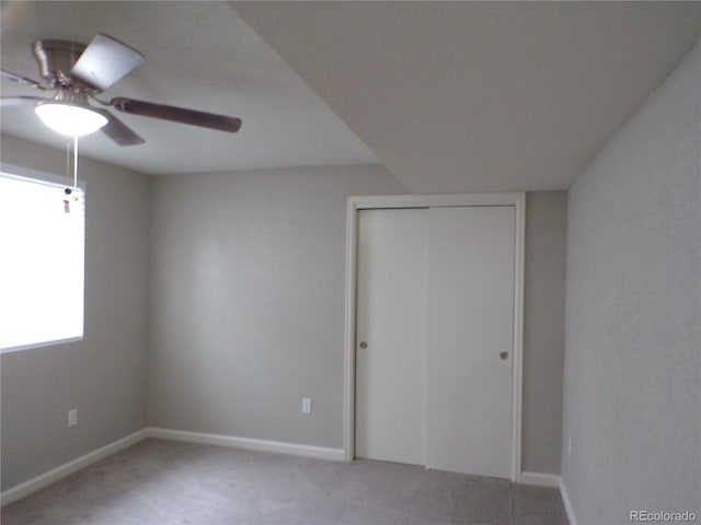 unfurnished bedroom featuring carpet floors, a closet, and ceiling fan