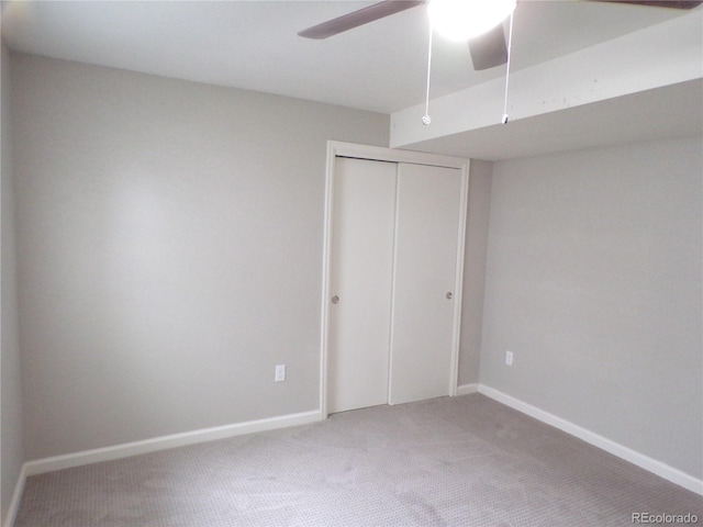 unfurnished bedroom featuring carpet, a closet, and ceiling fan