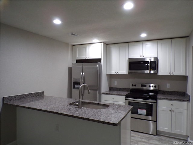 kitchen featuring kitchen peninsula, sink, white cabinetry, and stainless steel appliances