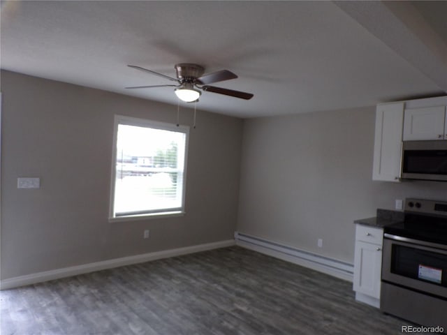 kitchen with white cabinets, dark hardwood / wood-style flooring, baseboard heating, and stainless steel appliances