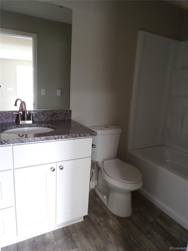 full bathroom featuring vanity, toilet, wood-type flooring, and bathing tub / shower combination