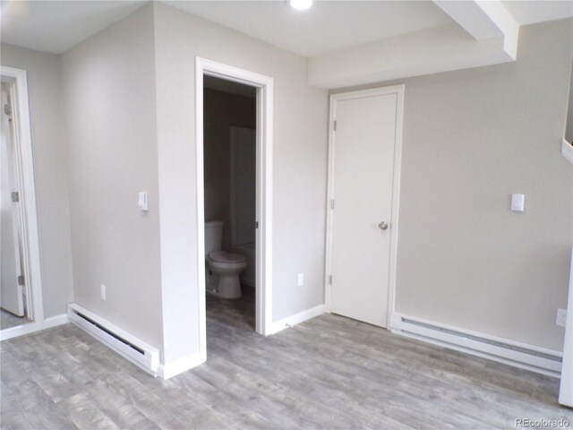 empty room featuring light wood-type flooring and baseboard heating