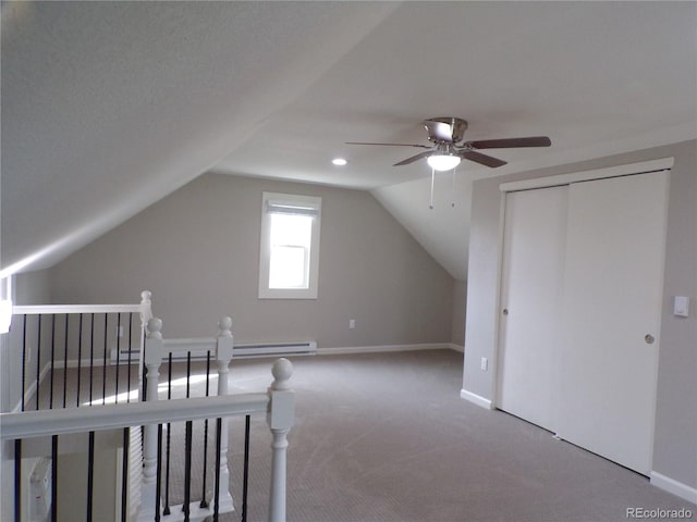 carpeted bedroom featuring ceiling fan, a closet, lofted ceiling, and a baseboard heating unit