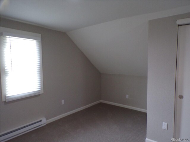 bonus room featuring vaulted ceiling, dark carpet, and a baseboard heating unit