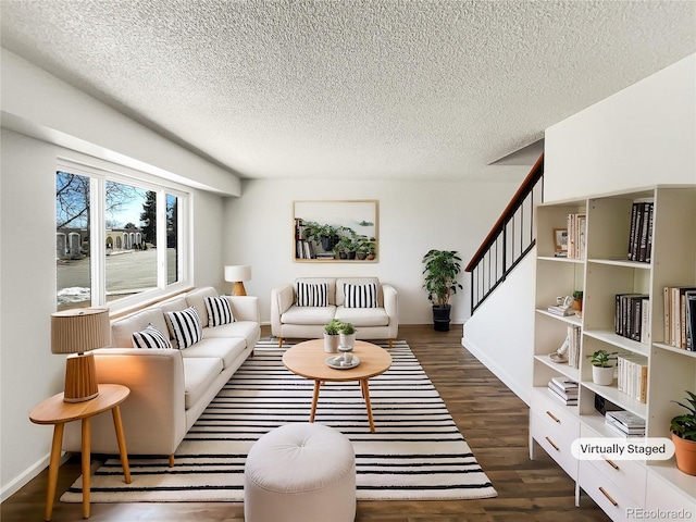 living room with baseboards, stairway, a textured ceiling, and wood finished floors