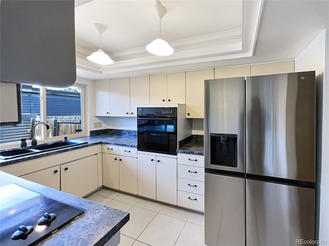 kitchen with a raised ceiling, a sink, black appliances, and cream cabinets