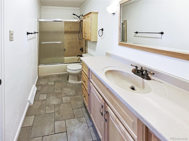 bathroom featuring visible vents, baseboards, toilet, combined bath / shower with glass door, and vanity