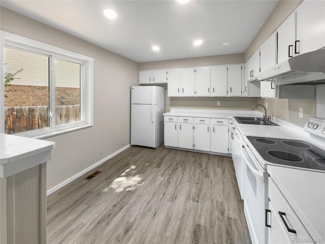 kitchen with visible vents, light wood-type flooring, a sink, white appliances, and baseboards