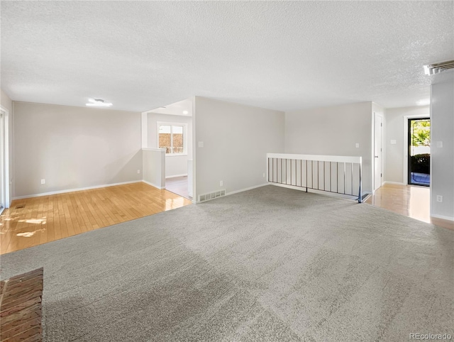 spare room featuring visible vents, plenty of natural light, and carpet