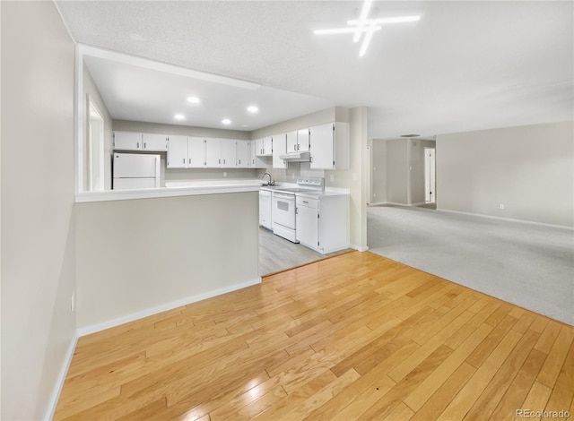 kitchen with light wood-style flooring, white cabinets, white appliances, and light countertops