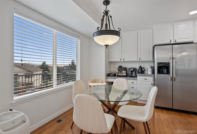 dining area with baseboards, visible vents, plenty of natural light, and light wood-type flooring