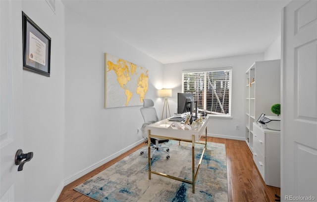 office area featuring baseboards and wood finished floors