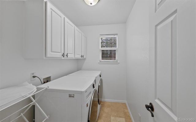 washroom featuring independent washer and dryer, baseboards, and cabinet space