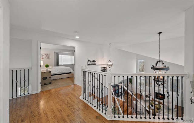 hall with recessed lighting, a chandelier, and wood finished floors