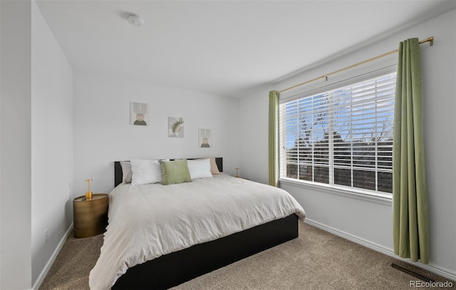 carpeted bedroom with visible vents and baseboards