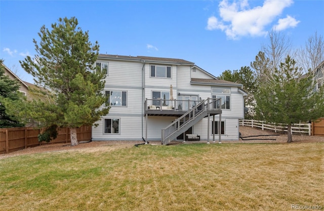 rear view of property with a lawn, a fenced backyard, a wooden deck, and stairway