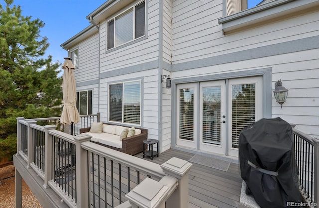 wooden deck featuring outdoor lounge area and a grill