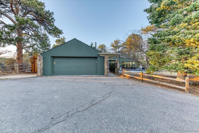 view of front of property with a detached garage and fence