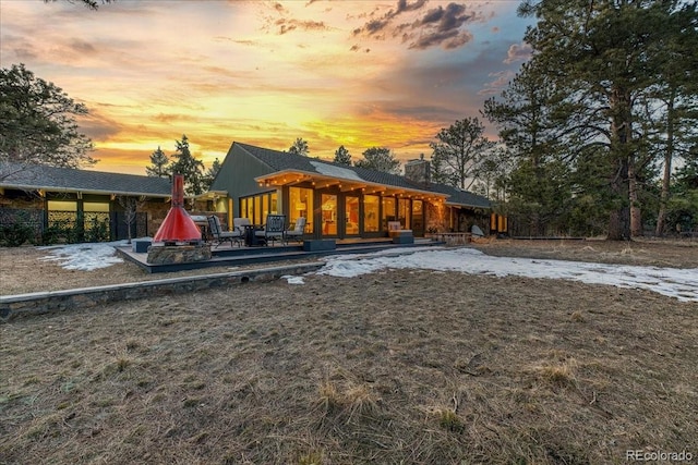 back of property at dusk with a chimney