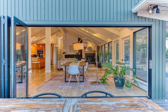 sunroom / solarium featuring lofted ceiling with beams and exterior fireplace