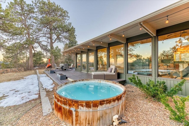 view of swimming pool featuring a deck and a jacuzzi