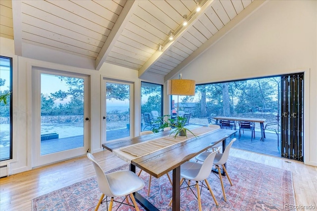 dining room with vaulted ceiling with beams, wood finished floors, wood ceiling, and a healthy amount of sunlight