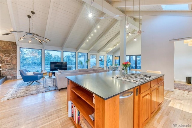 kitchen with light wood-style flooring, a kitchen island, open floor plan, stainless steel gas cooktop, and open shelves