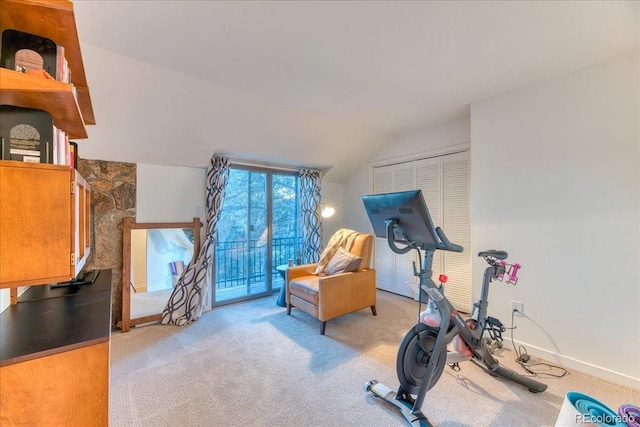 exercise room featuring lofted ceiling, light colored carpet, and baseboards