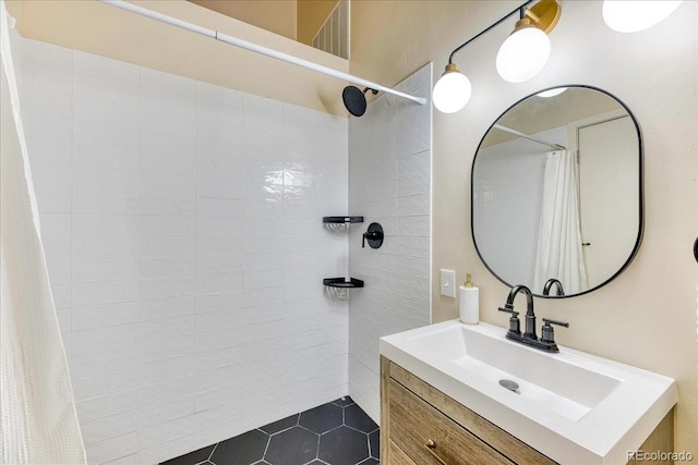 bathroom featuring tile patterned floors, a tile shower, and vanity