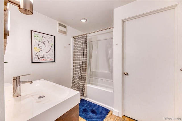 bathroom featuring visible vents, vanity, and shower / bath combo with shower curtain