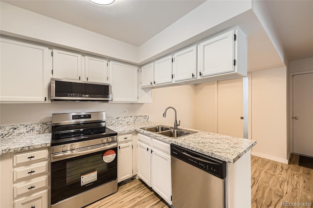 kitchen featuring sink, stainless steel appliances, light stone counters, light hardwood / wood-style flooring, and white cabinets