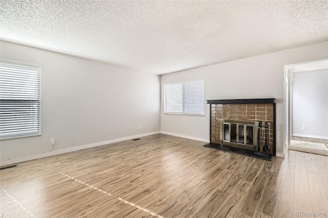 unfurnished living room featuring hardwood / wood-style flooring and a textured ceiling