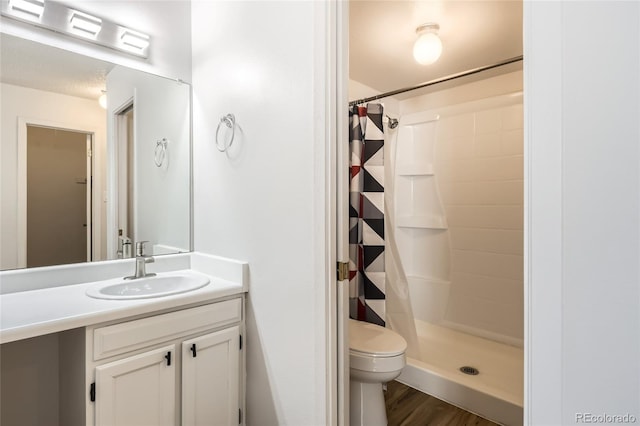 bathroom with vanity, curtained shower, wood-type flooring, and toilet