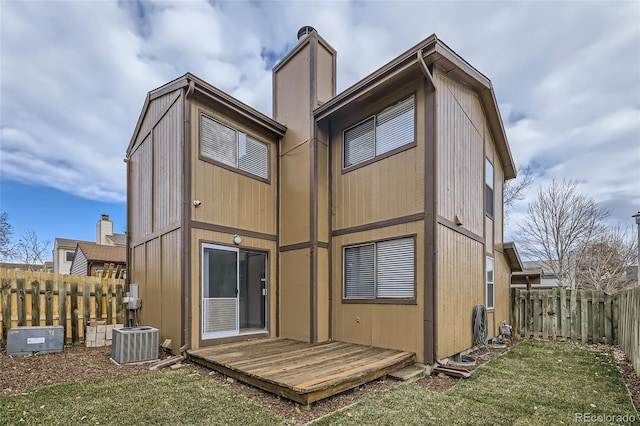 rear view of property with central AC, a yard, and a deck