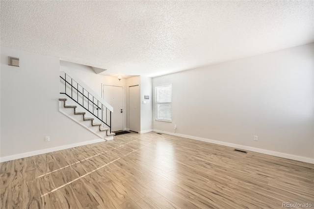 interior space with light hardwood / wood-style flooring and a textured ceiling