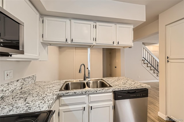 kitchen with sink, light hardwood / wood-style floors, white cabinets, and appliances with stainless steel finishes