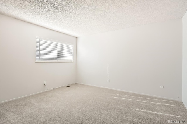 carpeted spare room featuring a textured ceiling