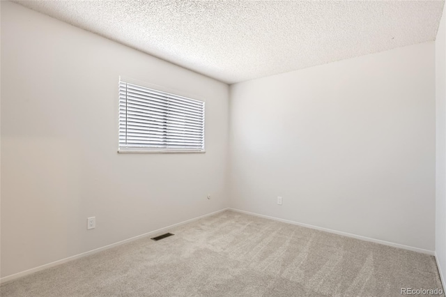 carpeted empty room featuring a textured ceiling