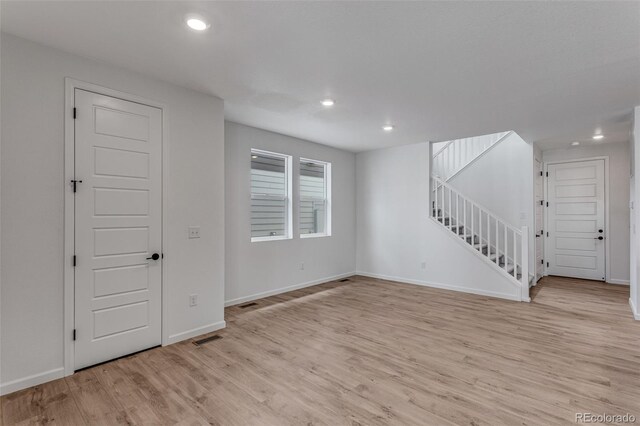 1415 Great Western Dr, Longmont, CO 80501 - unfurnished living room featuring recessed lighting, light wood-style flooring, stairway, and baseboards