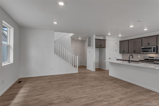 1415 Great Western Dr, Longmont, CO 80501 - kitchen with appliances with stainless steel finishes, a sink, light wood finished floors, recessed lighting, and light countertops