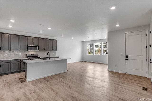 1415 Great Western Dr, Longmont, CO 80501 - kitchen featuring stainless steel appliances, open floor plan, backsplash, light wood-style flooring, and recessed lighting