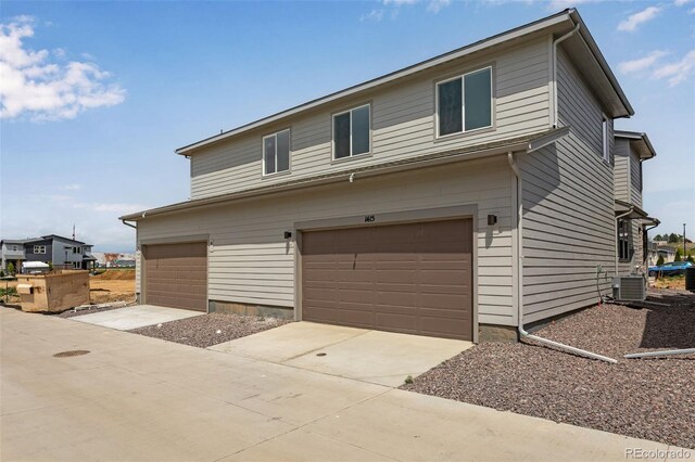 1415 Great Western Dr, Longmont, CO 80501 - view of front facade with cooling unit, an attached garage, and driveway