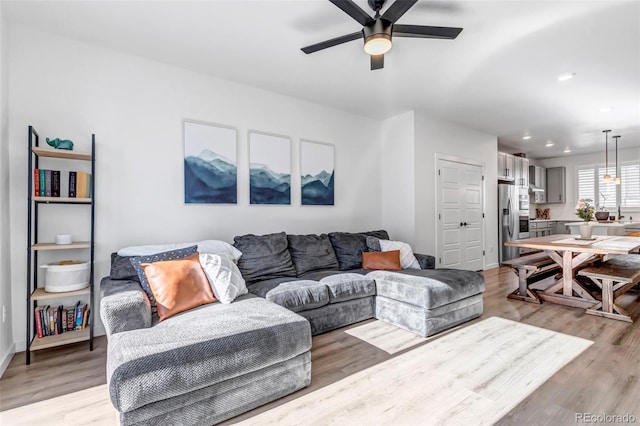 living room featuring ceiling fan and light hardwood / wood-style flooring