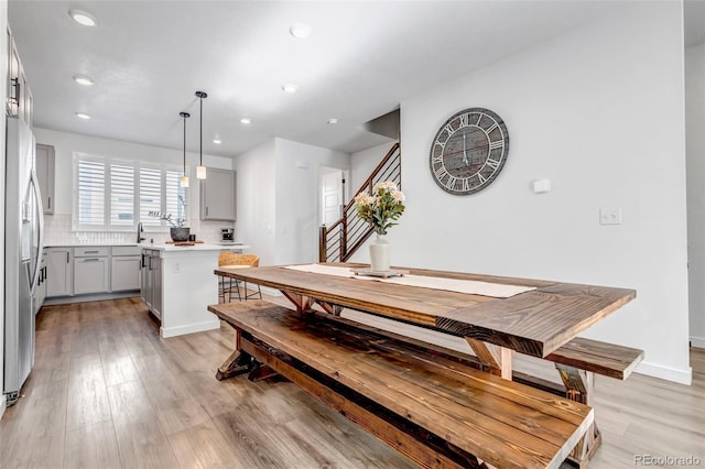 dining area with sink and light hardwood / wood-style flooring