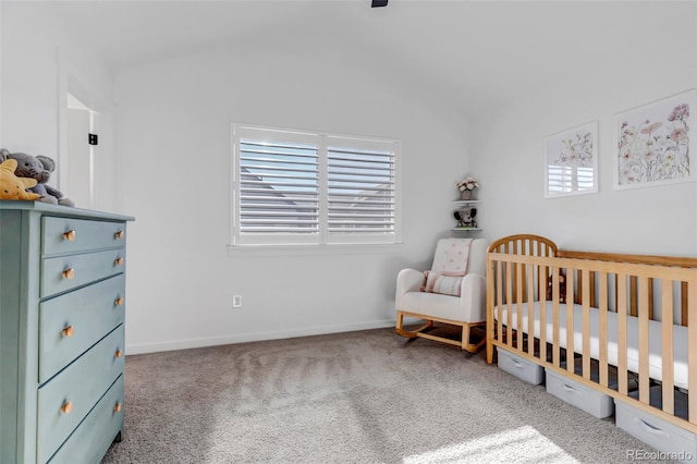 carpeted bedroom featuring a crib and vaulted ceiling